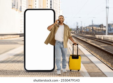 A man stands at a train station, holding a suitcase while talking on his phone. Beside him is an oversized smartphone, emphasizing modern travel and connectivity. - Powered by Shutterstock