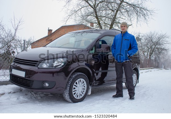 man stands in winter near\
car,in winter, a man stands near a brand new car, a man purchased a\
car