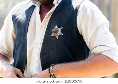 A man with the star shaped sheriff badge in his vest. Wild west justice officer and lawman - Shutterstock ID 1183505770
