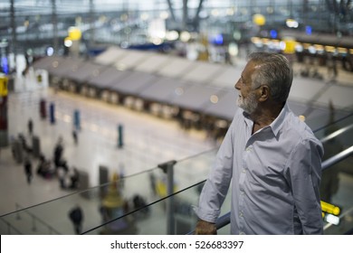 Man Staring At The Airport Crowd Downstairs