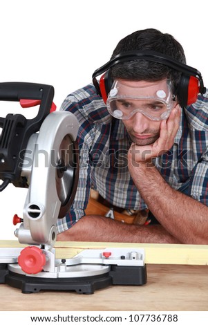 A man staring at a circular saw.