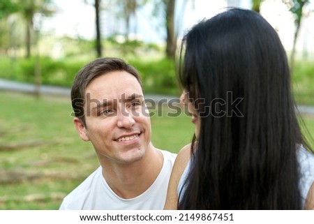Man staring at his partner while sitting in a park
