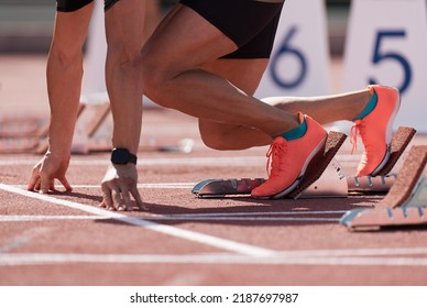 Man In A Start Block On An Athletic Track. A Sprinter In A Track And Field Race Is Poised At The Starting Line Waiting For The Start