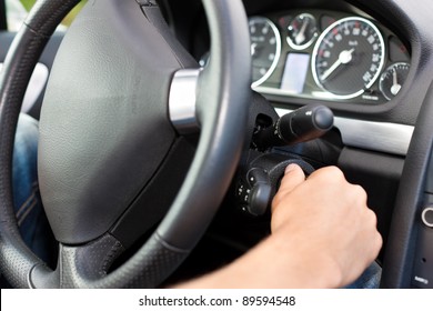 Man Is Starting His Car; He Is Turning The Ignition Key Under The Wheel