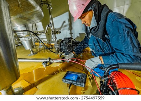 A man starts using a weld pipe stainless inspection camera. The light monitor shows images from the camera head that the inspector is