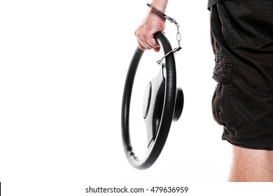 man with steering wheel and handcuffs is standing in front of white, backview. concept grand 