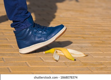 Man stepping on slippery banana skin or peel. About to slide with a banana peel. Unexpected accident concept