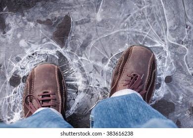 Man Steps On Frozen Puddle With Thin Ice.