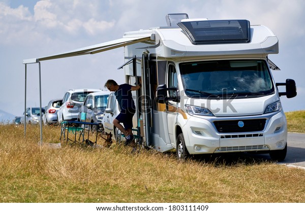 A Man Steps Out\
of a RV, Parked Along the Road on a Summer Day. MAJELLA, ABRUZZO,\
ITALY - AUGUST 2, 2020