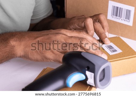 Man sticks the bar code to the brown box to manage the inventory