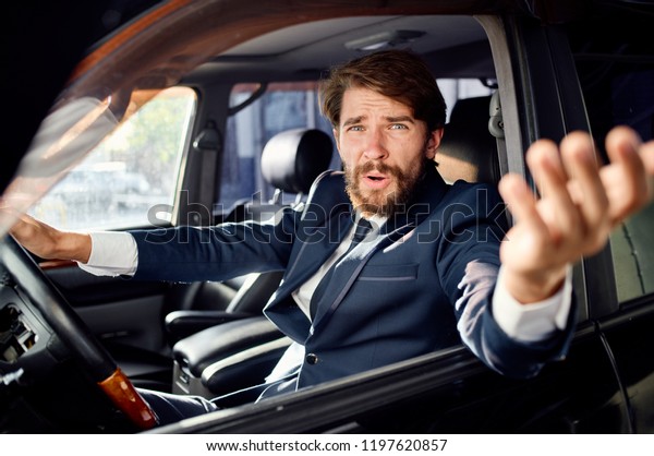a man sticks his hand out of a car window               \
       