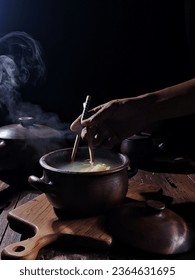 a man was stirring noodles - Shutterstock ID 2364631695