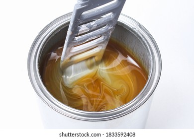 A man stirring white paint in a can on a white background. Renovation concept.