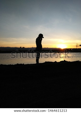 a man stood enjoying the sunset while pondering