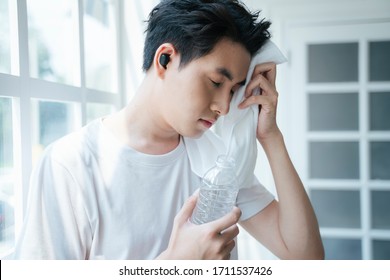 A Man Stop Workout And Drinking The Water While Wipe The Sweat.