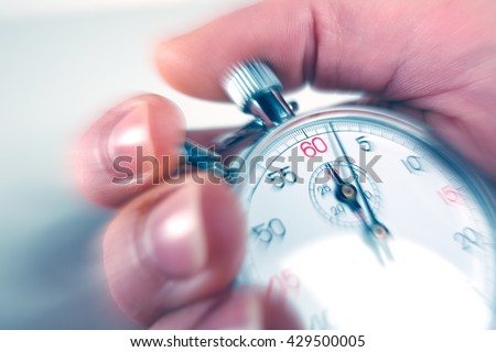 man stopping a stopwatch with motion blur