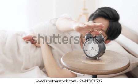 A man stops a ringing alarm clock