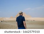 man in a straw hat on the background of the Egyptian pyramids