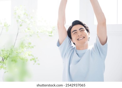 A man stretches and relaxes by a bright window. - Powered by Shutterstock