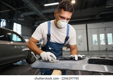 Man stripping paint before painting car detail - Powered by Shutterstock