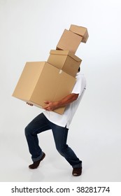 A Man Struggling To Carry Moving Boxes.