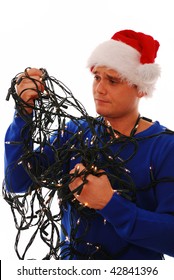 Man struggling with christmas tree lights on white isolated background