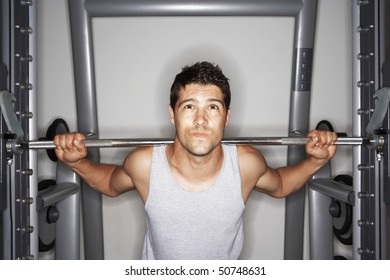 Man Struggling To Lift Weights On Weight Machine