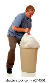 A Man Struggling To Pull A Heavy Load From A Kitchen-sized Trash Can.