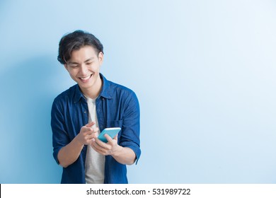 Man Student Smile And Use Phone Isolated On Blue Background,asian