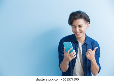 Man Student Smile And Use Phone Isolated On Blue Background,asian