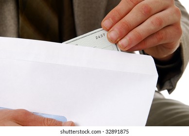 A Man Stuffing A Check In An Envelope