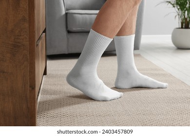 Hombre en elegantes calcetines blancos en interiores, armario