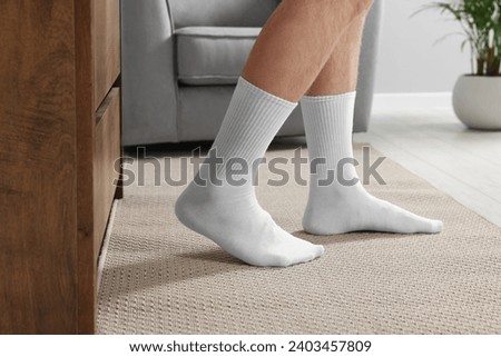 Man in stylish white socks indoors, closeup