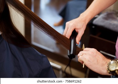 Man Stylist Align The Customer's Hair With Straightener