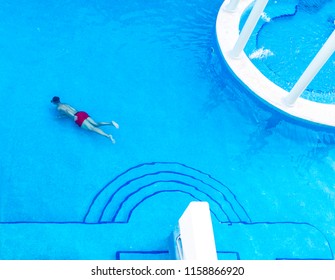 Man Submerged Or Swimming Under Water In A Luxury Blue Tiled Pool Wearing A Snorkle And Relaxing On Holiday Or Vacation