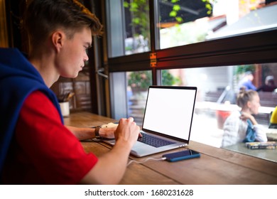 Man Successful Publication Specialist Using Laptop Computer With Empty Mock Up Copy Space Screen Background For Promotional Content While Sitting In Coffee Shop Near Window.