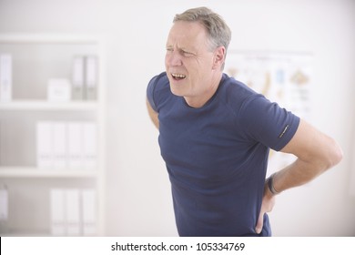 Man suffering from backache at office - Powered by Shutterstock