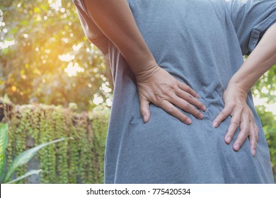 A man suffering from backache, spinal injury and muscle issue problem at outdoor.