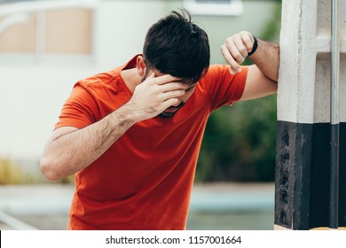 Man Suffering From Dizziness With Difficulty Standing Up While Leaning On Wall