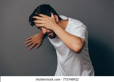 Man Suffering From Dizziness With Difficulty Standing Up While Leaning On Wall