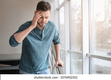 Man Suffering From Headache Near Window In Office