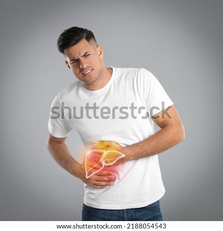 Man suffering from liver pain on grey background