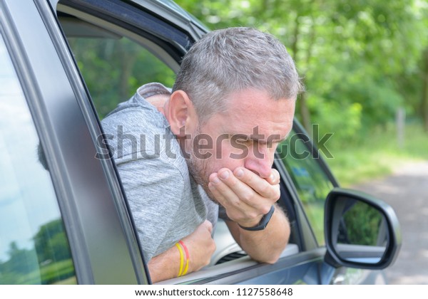Man suffering\
from motion sickness in a\
car