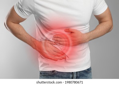 Man suffering from pain in lower right abdomen on light grey background, closeup. Acute appendicitis - Shutterstock ID 1980780671