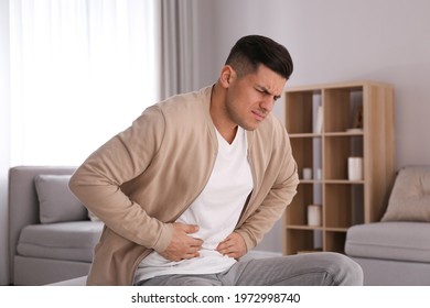 Man suffering from stomach ache at home. Food poisoning