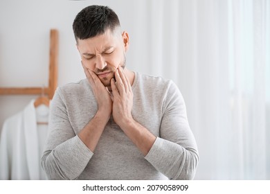 Man suffering from tooth ache in morning - Shutterstock ID 2079058909