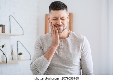 Man suffering from tooth ache in morning - Shutterstock ID 2079058960