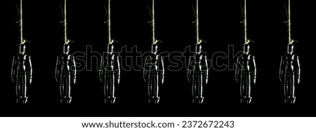 Man suicide.Hanging wooden puppet with a rope on a black background.Suicide Puppet