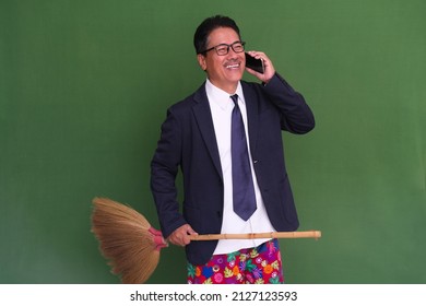 A Man In A Suit And Boxer Shorts Holds A Broom While Talking On The Phone; Laugh.