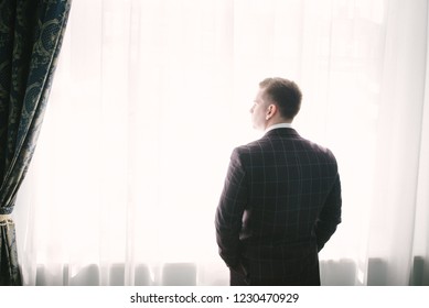 man in a suit by the window - Shutterstock ID 1230470929